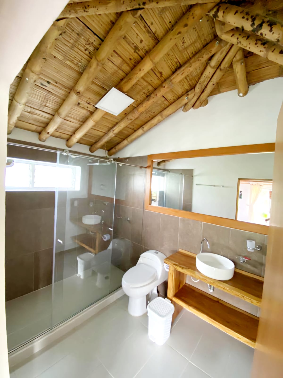 Baño moderno con acabados en madera en Finca Hotel Palma de Iraka